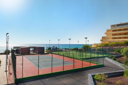 a tennis court with the ocean in the background at Iberostar Waves Playa Gaviotas All Inclusive in Morro del Jable