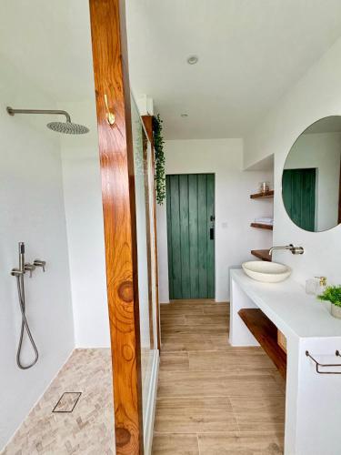 a bathroom with a wooden door and a sink at Casa Maruxa in Valdoviño