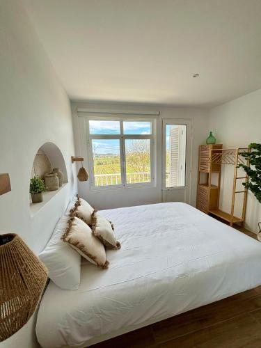 a white bedroom with a large white bed with pillows at Casa Maruxa in Valdoviño