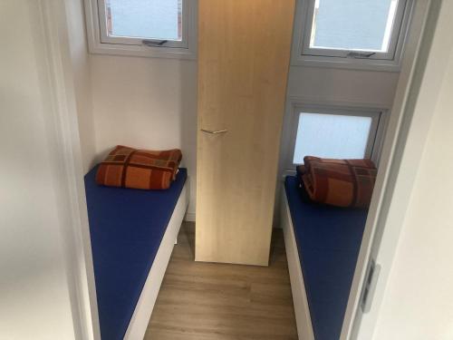 a hallway with two beds in a room with windows at KD 822 - Vakantiepark Kijkduin in The Hague