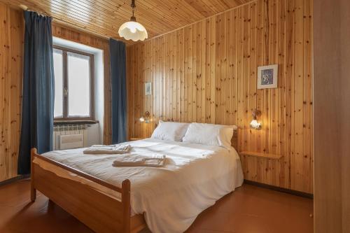 a bedroom with a large bed with wooden walls at Due gnomi in Temù