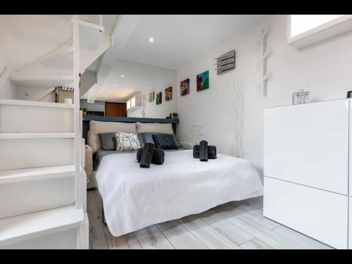 a white bedroom with a bed and a staircase at Duomo In 8 Stop in Milan