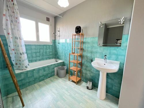 une salle de bain avec un lavabo, des toilettes et une baignoire dans l'établissement Appartement dans une maison avec entrée indépendante à 500m de la plage, à Santec