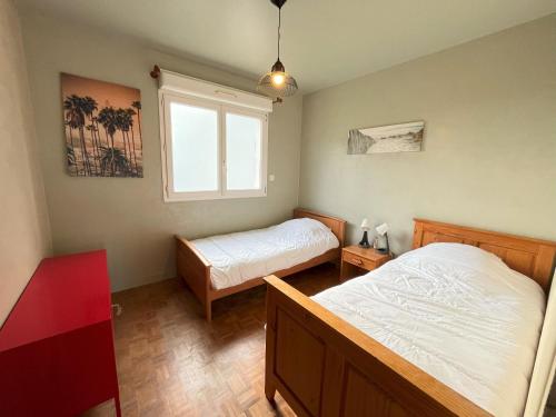 une chambre avec deux lits et une fenêtre dans l'établissement Appartement dans une maison avec entrée indépendante à 500m de la plage, à Santec