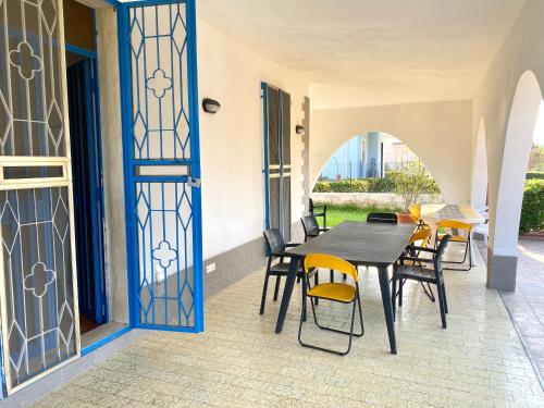 a patio with a table and chairs and a glass door at Pearl of the sea in Arenella