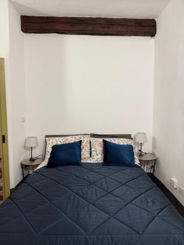 a bedroom with a blue bed with two blue pillows at Palazzo Antico in Sassari