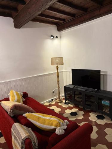 a living room with a red couch and a flat screen tv at Palazzo Antico in Sassari
