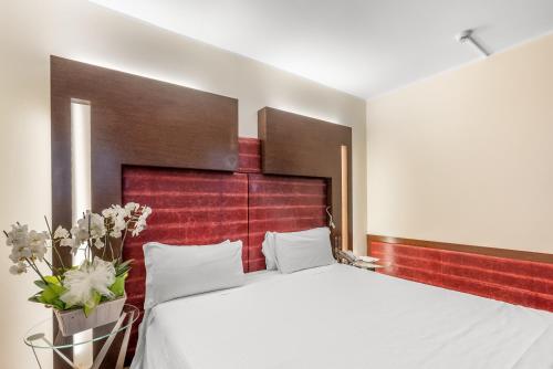 a bedroom with a large bed with a red headboard at Art Hotel Navigli in Milan