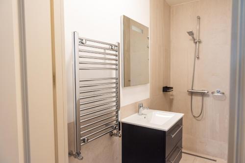 Un baño con lavabo y ducha con espejo. en Canal View Apartment, en Ámsterdam