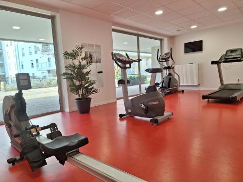 a gym with treadmills and exercise bikes in a room at Appart Hotel Odalys City Metz Manufacture in Metz