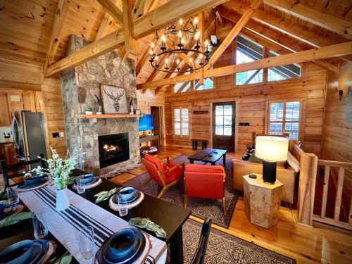 a living room with a fireplace in a log cabin at Mountain Hideaway - Hot Tub, Fire Pit, Close to Town in Ellijay