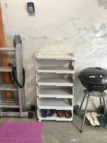 a stack of empty shelves next to a grill at 7pax, 2 AC BR,Videoke,Games,Netflix,Cook,Parking in Rodriguez
