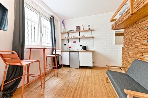 un salon avec une table et des chaises et une cuisine dans l'établissement Studio avec Mezzanine Boulevard Voltaire-V, à Paris