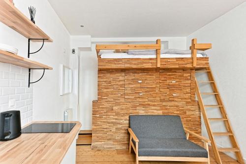 Cette chambre est dotée de 2 lits superposés et d'un mur en briques. dans l'établissement Studio avec Mezzanine Boulevard Voltaire-V, à Paris