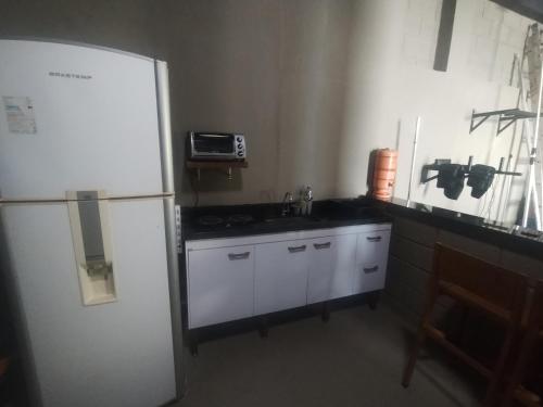 a kitchen with a white refrigerator and a sink at Casa de Charme Camargos in São João del Rei