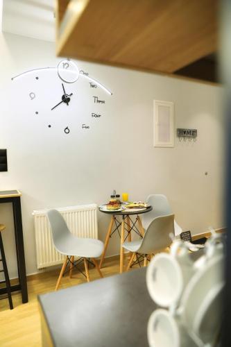 a clock on a wall with a table and chairs at Lago Suite in Kastoria