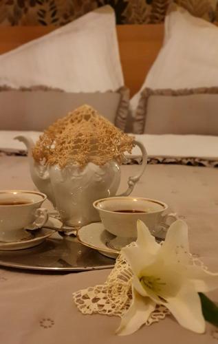 a table with two cups and a bowl of food at Csacsiország Vendégház in Nógrádsáp