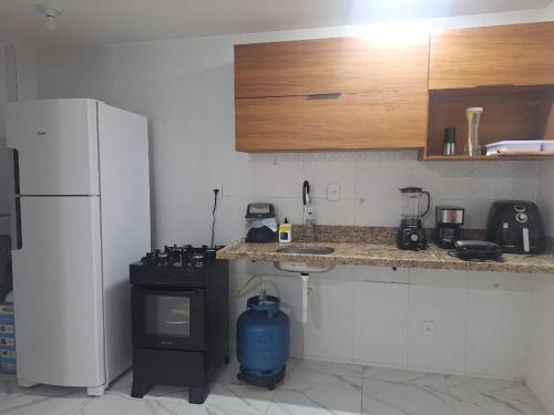 a kitchen with a stove and a refrigerator at Casa de praia Imbassaí in Mata de Sao Joao