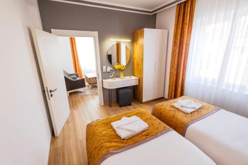 a bathroom with two beds and a sink and a mirror at Continent Hotel Kapadokus Thermal in Guzelyurt