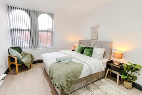 a bedroom with a large bed and a chair at Charming & Cosy 2 BR Flat, Fast Wifi -Sleeps 5 in Leeds