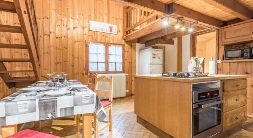 een keuken met een tafel en een fornuis bij Chalet confortable à Saint-Gervais-les-Bains 60 m² vue montagne in Saint-Gervais-les-Bains