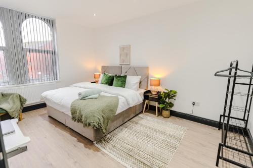 a bedroom with a large bed with green pillows at Charming & Cosy 2 BR Flat, Fast Wifi -Sleeps 5 in Leeds