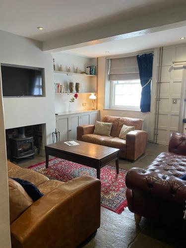 a living room with a couch and a coffee table at Little Monmouth 4 bedroom cottage, Old town Lyme Regis, dog friendly and parking in Lyme Regis