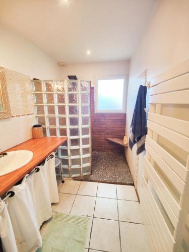 une salle de bain avec un lavabo et un comptoir avec des serviettes dans l'établissement La chambre Soleil, à Gujan-Mestras