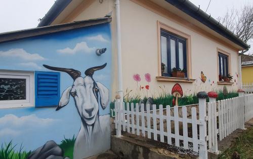 a mural of a goat on the side of a house at Csacsiország Vendégház in Nógrádsáp