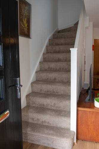 a stairway in a home with a gray staircase at Coorie Voe in Stromness