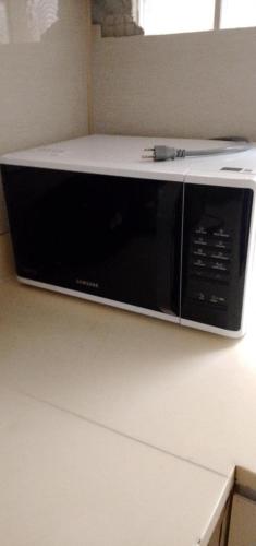 un microondas sentado en la parte superior de un mostrador en Hacienda Grande , Catalunan Grande, en Davao City