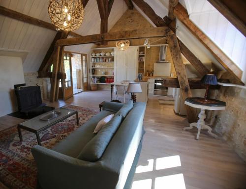 un salon avec un canapé et une table dans l'établissement Manoir Beauregard Dordogne, à Clermont-de-Beauregard