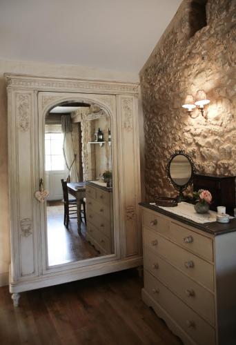 La salle de bains est pourvue d'un grand miroir et d'une commode. dans l'établissement Manoir Beauregard Dordogne, à Clermont-de-Beauregard