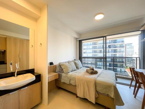 Nine: Conforto e Sofisticação no Jardim Paulista في ساو باولو: غرفة نوم بسرير ومغسلة ونافذة