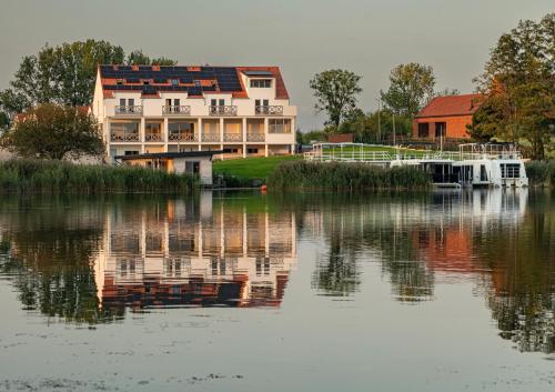 a large house is reflected in a body of water at Spectrum Centrum Terapii i Rozwoju in Tomaszkowo