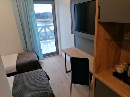 a room with a bed and a tv and a window at Spectrum Centrum Terapii i Rozwoju in Tomaszkowo