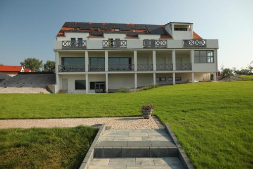a large white house with a grassy field in front of it at Spectrum Centrum Terapii i Rozwoju in Tomaszkowo
