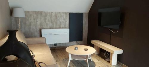 a small room with a table and a tv at Gite équestre - Domaine aux charmes d'Ethan in Hannut