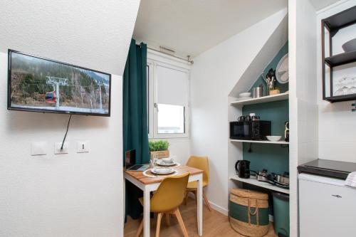 une petite salle à manger avec une table et une télévision dans l'établissement Le tiny, à Colmar