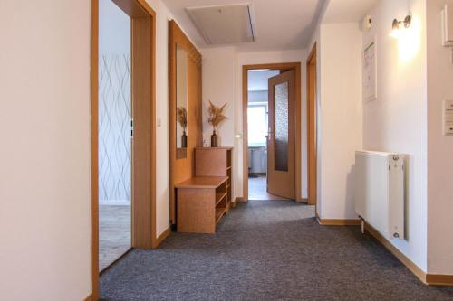 a corridor of a room with a door and a refrigerator at Hotel Carolaruh in Bad Elster