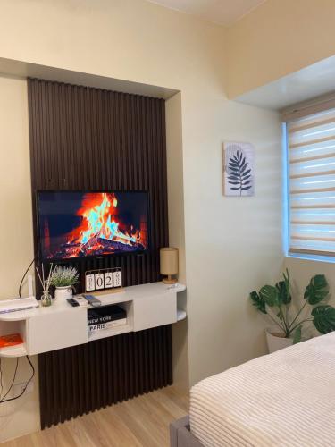 ダバオシティにあるAvida Davao Cozy Studio by Gia's Placeの壁にテレビが取り付けられたリビングルーム