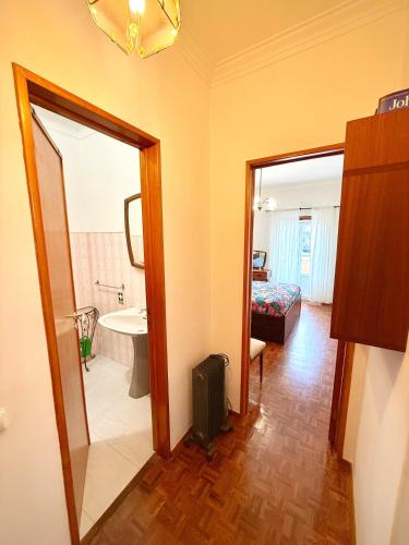 a room with a bathroom with a sink and a mirror at Casa da Mariazinha in Costa da Caparica