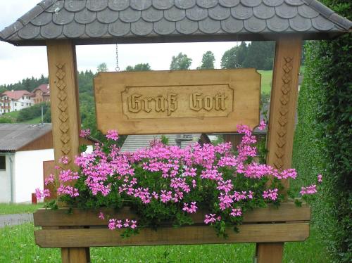 a flower box with a sign in a gazebo at Ferienwohnung Hinterdorfer in Unterweissenbach