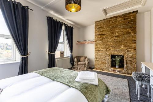 a bedroom with a bed and a fireplace at Holme Valley View in Holmfirth