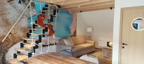 a living room with a spiral staircase and a couch at Gite Maritime - Domaine aux charmes d'Ethan in Hannut