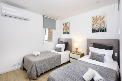 ローレにあるCasa Bellaの白い壁のベッドルーム1室(ベッド2台付)