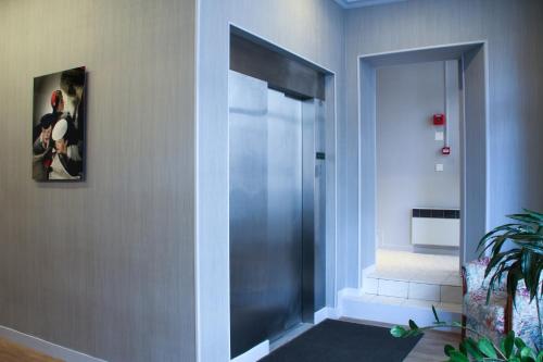 a hallway with a glass door with a picture on the wall at Hôtel De France in Boulogne-Billancourt