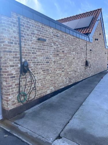 a hose hooked up to a brick wall at Gite Maritime - Domaine aux charmes d'Ethan in Hannut