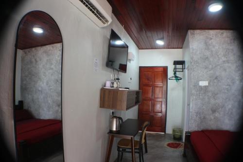 a hallway with a room with a red couch and a table at Umang-umang Chalet in Kampong Tanjong Dahan