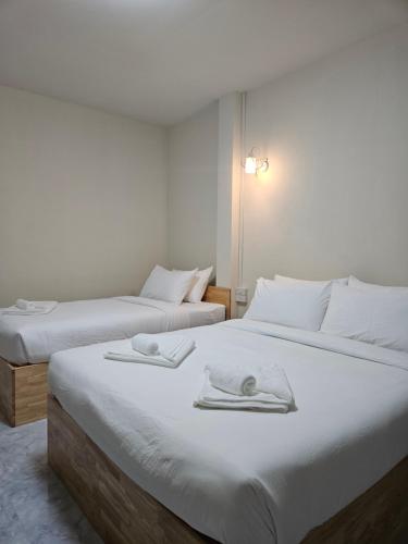 deux lits dans une chambre d'hôtel avec des serviettes dessus dans l'établissement KK Poshtel, à Don Muang Airport